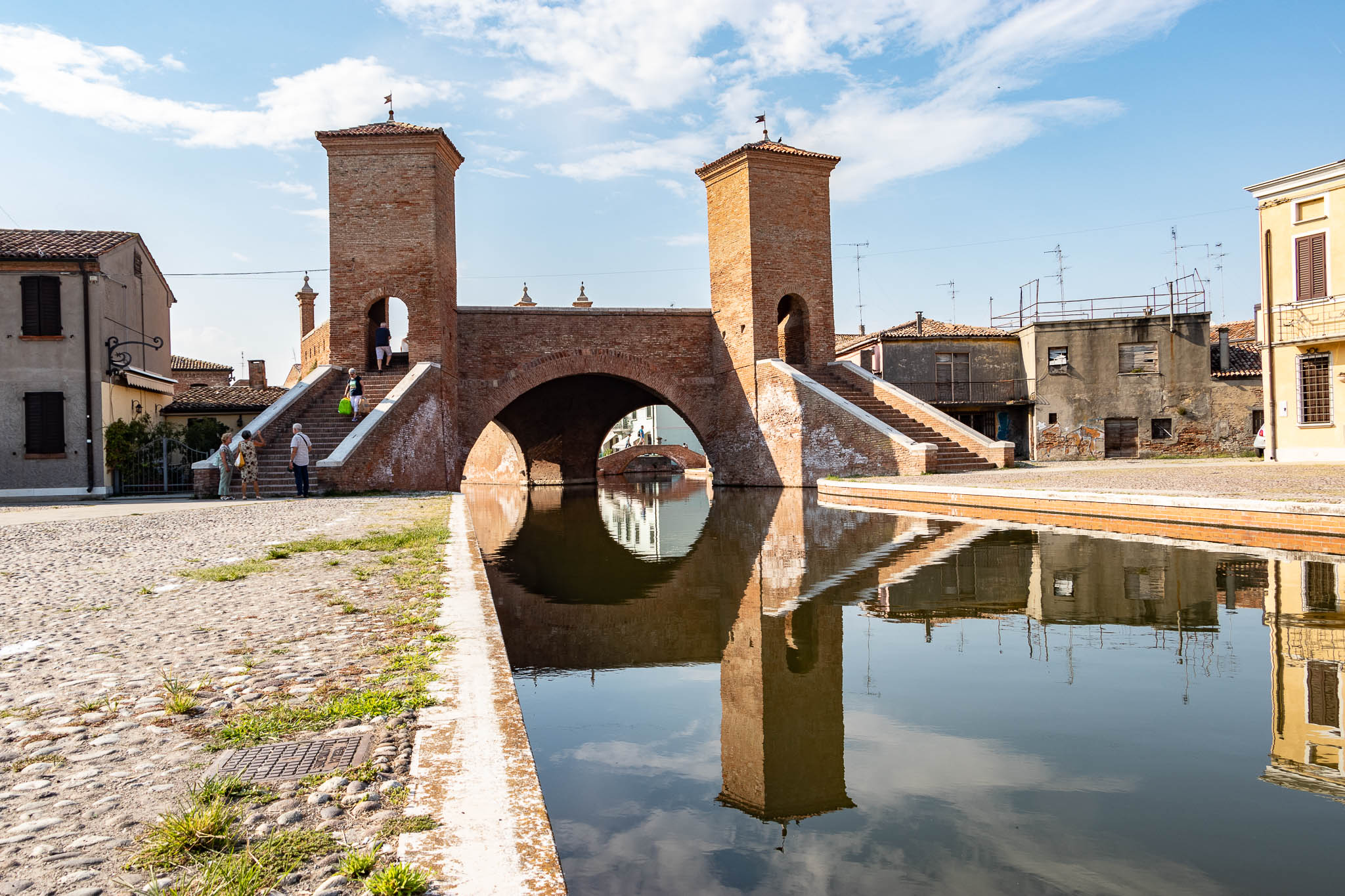 Standing on the edge of one of canals in Comacchio in Emilia Romagna. The bridge that we are looking at is a 3-way-bridge out of brick stones...
